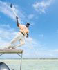 A bonefishing guide poles a skiff in the Bahamas.